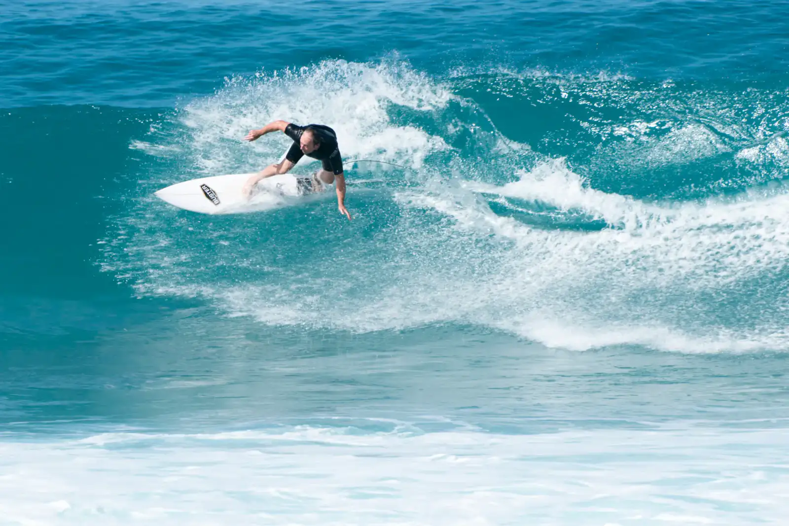 Spotguiding auf Fuerteventura – Surfer auf einer türkisblauen Welle